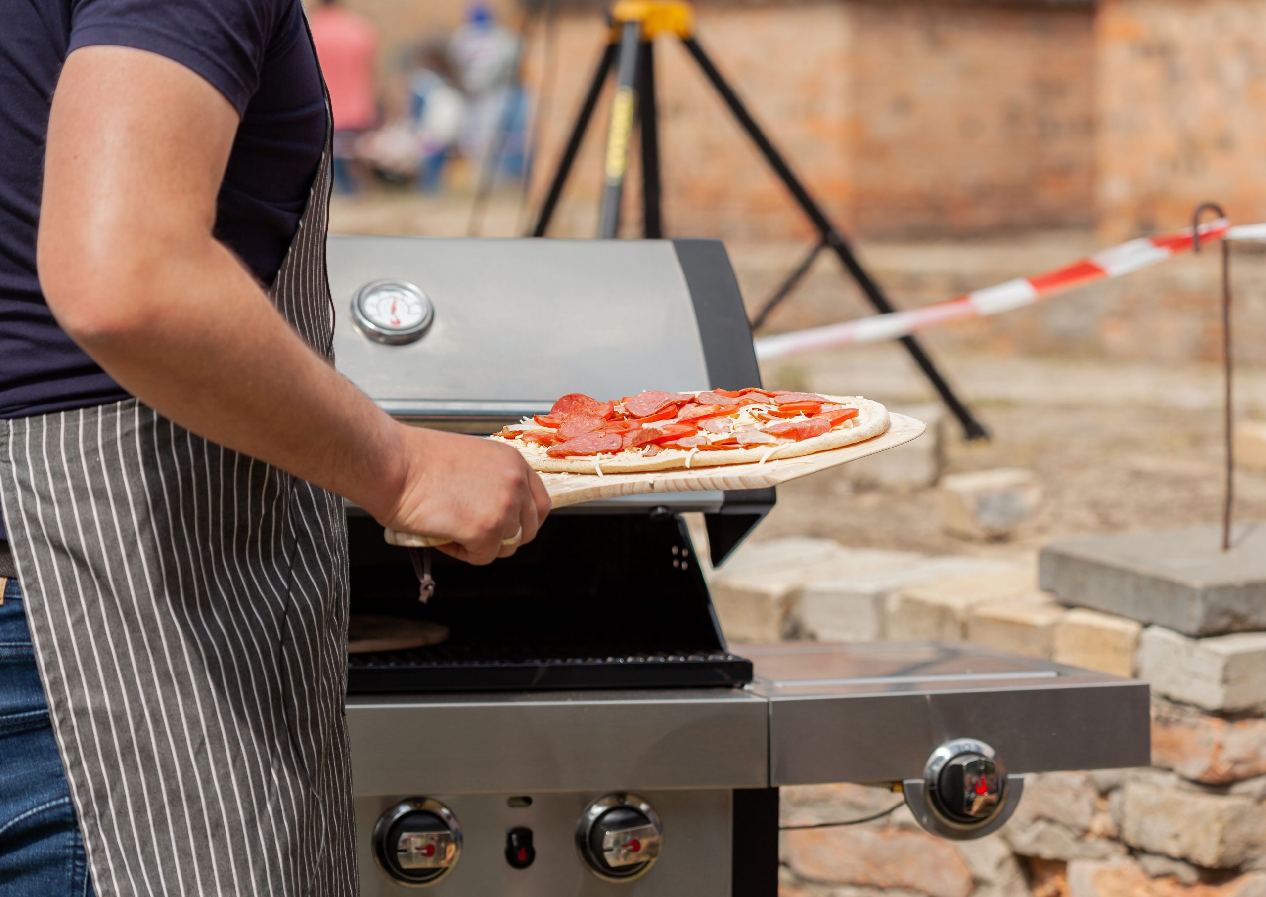 Pizza bager på sten i gasgrill
