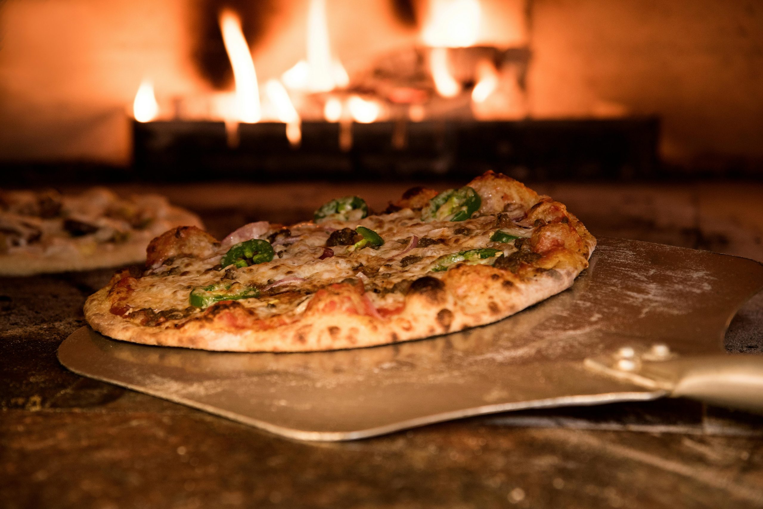 Pizza skubbes fra spade ind på stenen